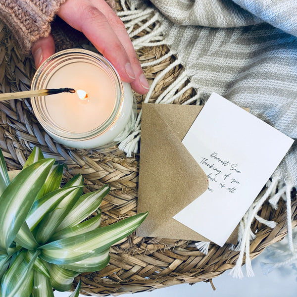 A gift card and scented soy wax candle next to a gift card.