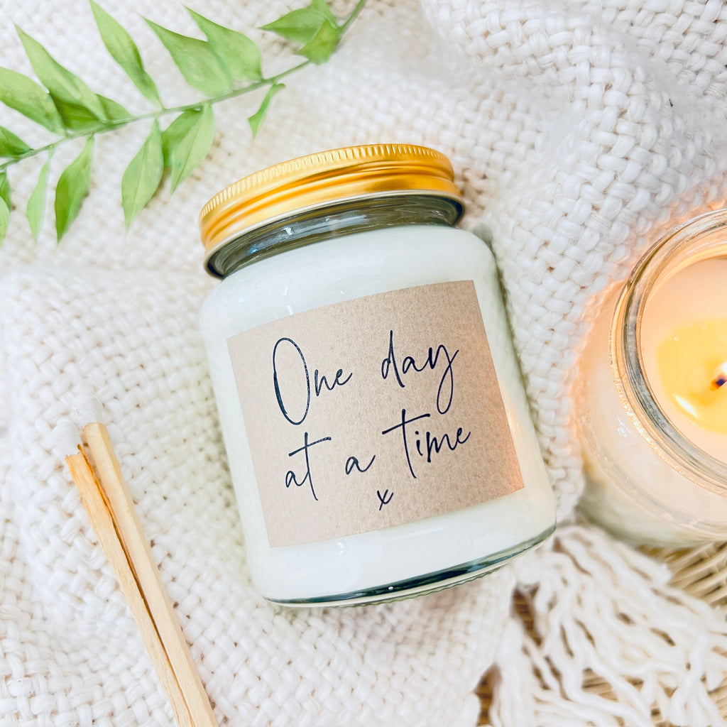 Soy Wax Scented Candle - One Day at a Time. A scented soy wax candle on a white fluffy background.