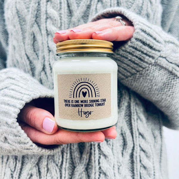 Hands holding a scented soy wax candle in a jar. 